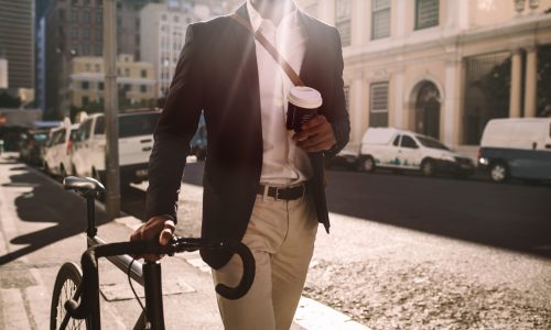 man walking with bike and coffee